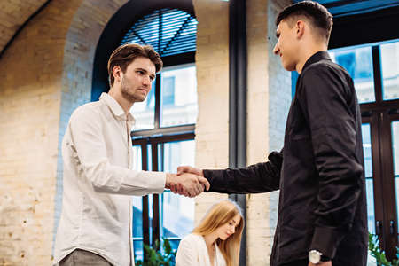 Businessmen shaking hands in officeの写真素材