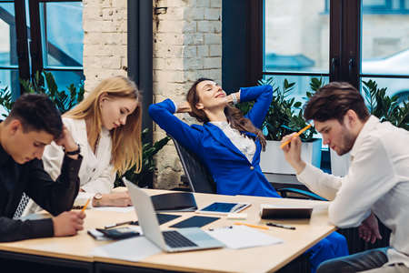 Businesswoman relax while her colleagues workingの写真素材