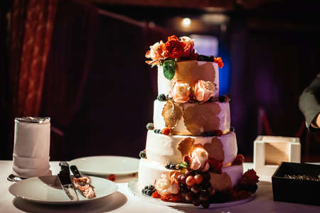 Four-tiered wedding cake on table in dark hallの写真素材