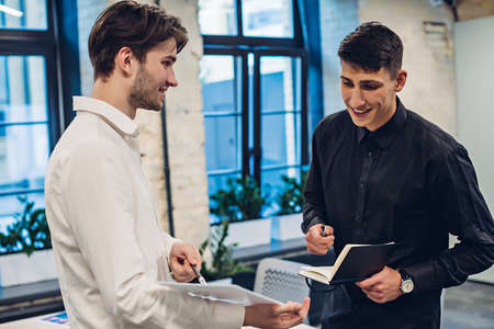 Businessman showing clipboard to colleagueの写真素材