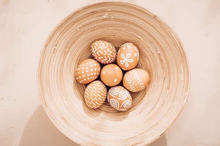 Minimalistic composition. Easter eggs on a plate. Eco style. Warm pastel tones. View from aboveの写真素材