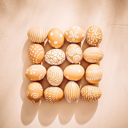 Easter eggs laid out squared on clay textured background.の写真素材