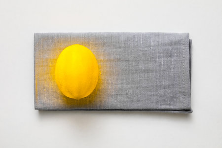 Color of the year 2021 creative concept. Yellow illuminating lemon on gray linen napkinの写真素材