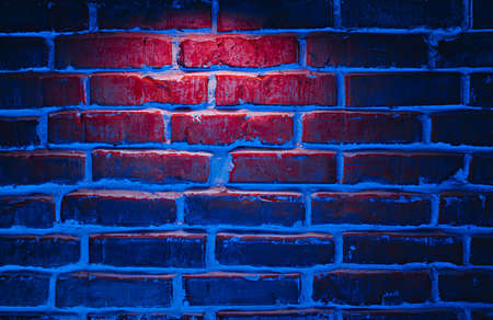 Brick wall texture background in red and blue neon lightsの写真素材