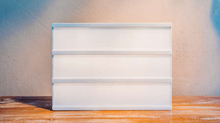 Blank cinema lightbox mockup in sunlight on wooden stand for your textの写真素材