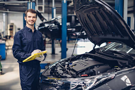 Auto car repair service center. Mechanic examining car engineの写真素材