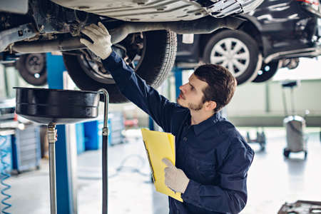 Auto car repair service center. Mechanic examining carの写真素材