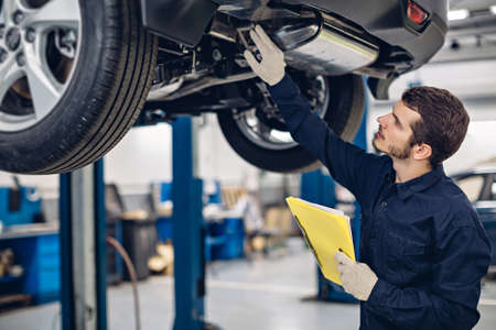 Auto car repair service center. Mechanic examining carの写真素材
