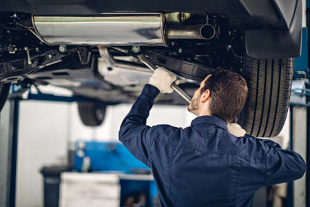 Auto car repair service center. Mechanic examining car suspensionの写真素材