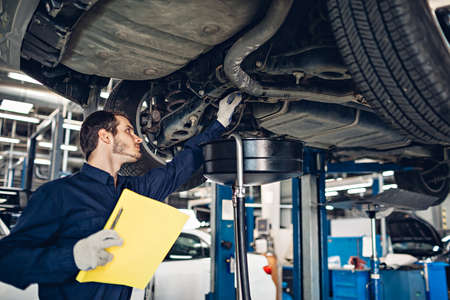 Auto car repair service center. Mechanic examining carの写真素材
