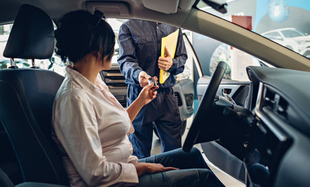 Car service center scene. The mechanic giving car key to the clientの写真素材