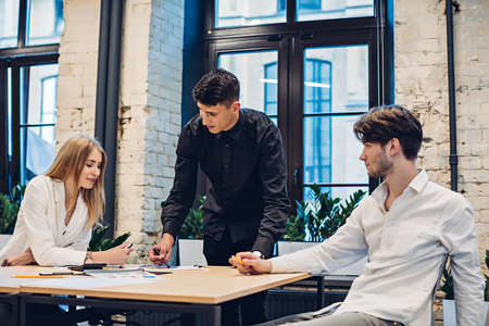Businessman showing graph to colleagues in officeの写真素材