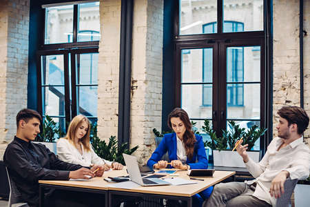 Sad businesspeople thinking at table in officeの写真素材