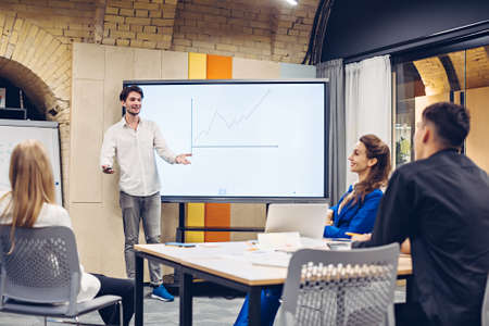 Businessman showing growth graph to colleaguesの写真素材