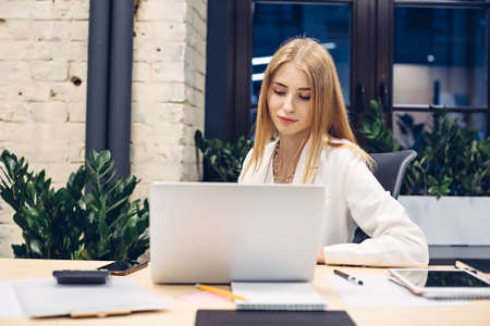 Businesswoman working on laptop in officeの写真素材