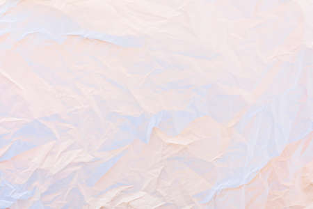 Crumpled paper in pastel pink and blue neon lights texture backgroundの写真素材