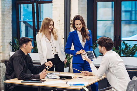 Businesswoman showing on laptop to colleaguesの写真素材