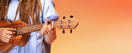 Faceless portrait of funny young woman playing ukulele. Happiness and carefree conceptの写真素材