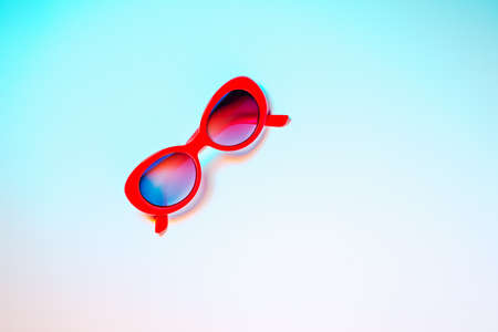 Red sunglasses with a copy space on a background of summer or neon colorsの写真素材