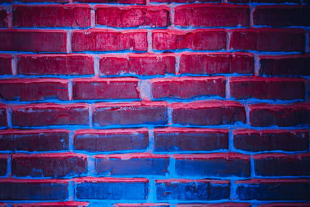 Brick wall texture background in red and blue neon lightsの写真素材