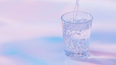 Water pouring into glass. Neon lights color aestheticsの写真素材