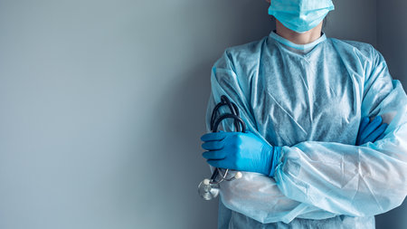 Medical worker portrait without face dressed in disposable medical gown and protective maskの写真素材