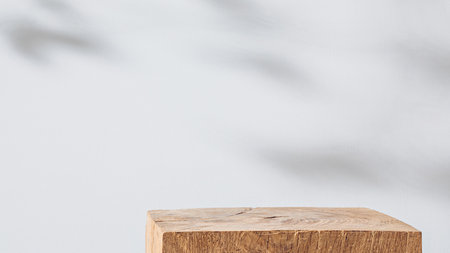 Wooden cubic podium on a white background with leaves shadowの写真素材