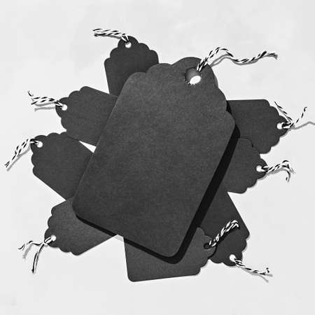 Black tags on concrete. Biggest one and many small. Black friday background with copy spaceの写真素材