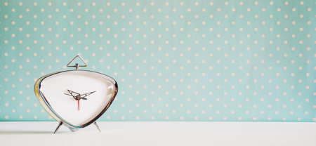 Vintage alarm clock on blue with white polka dot backgroundの写真素材