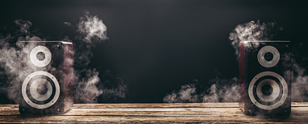 Two smoky audio speakers on wooden planks in the darkの写真素材