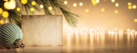 Aged kraft paper texture copy space with Christmas bauble on bokeh lights background. Cozy home decorの写真素材