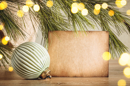 Aged kraft paper texture copy space with Christmas bauble on bokeh lights background. Cozy home decorの写真素材