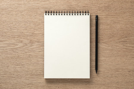 Notebook and black pencil on oak desk. Flat lay. Top viewの写真素材