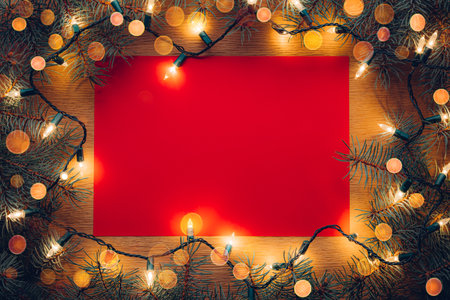 Red paper letter background with Christmas tree branches and Christmas lightsの写真素材