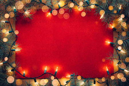 Red glitter paper letter texture background with Christmas tree branches and Christmas lightsの写真素材