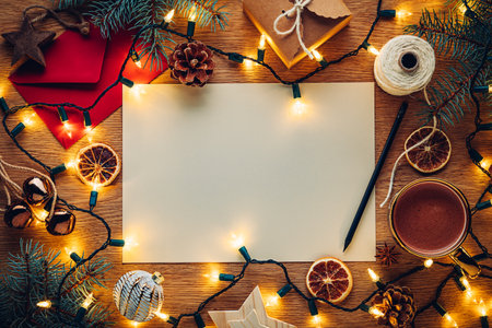Blank paper Christmas letter to or from Santa surrounded by Christmas decorations with hot chocolateの写真素材