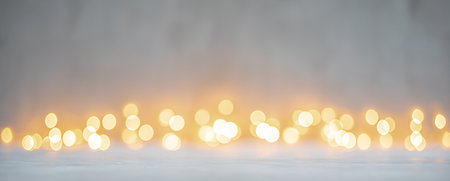 Yellow golden bokeh lights on white or light gray texture background for Christmas and winter holidaysの写真素材