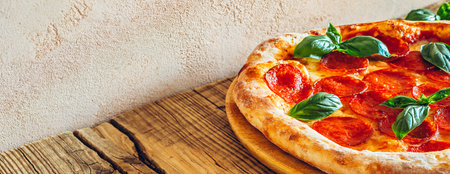 Pepperoni pizza with basil on a cutting boardの写真素材