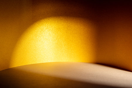 Play of golden hour sunlight and shadow on gold textured surfaces creating warm background.の写真素材