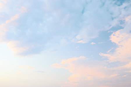A tranquil evening sky filled with soft pastel colors showcases fluffy clouds, creating a serene atmosphere and inviting relaxation and reflection.の写真素材