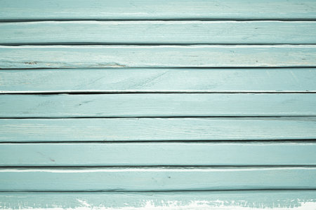 Weathered teal wooden planks showcase rustic texture, providing a serene backdrop. The color and grain add character.の写真素材