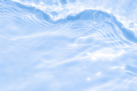 The clear water surface displays gentle ripples and reflections of light, capturing the essence of serenity and freshness on a sunny day.の写真素材
