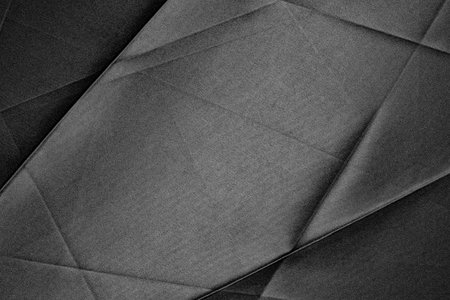 Black fabric texture featuring dynamic lines and deep shadows enhances the visual interest of the surface.の写真素材