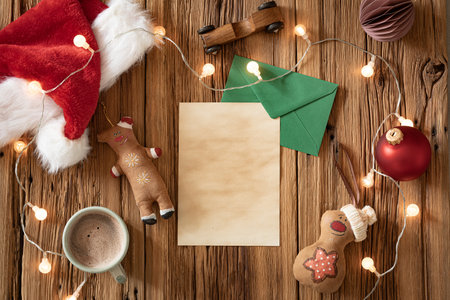 A warm, inviting setup features a mug of cocoa surrounded by holiday decorations. A blank note, festive ornaments, and playful toy figures create a charming atmosphere.の写真素材