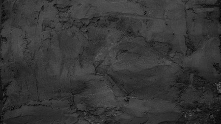 Black textured wall surface featuring intricate patterns and a rough grainy finish.の写真素材