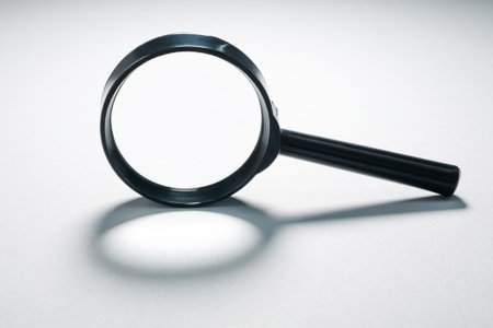 Magnifying glass on gray background. Concept of search, exploring details and in-depth examination.の写真素材