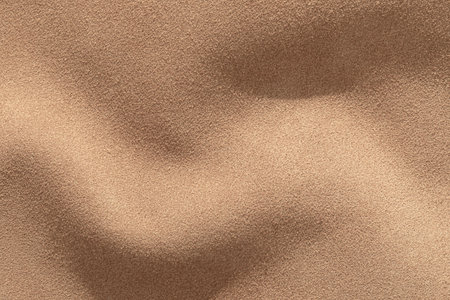 Suede leather texture background with smooth waves and warm tones creating a luxurious appearance.の写真素材