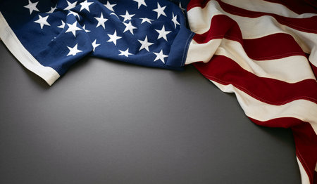 American flag draped elegantly on a dark gray surface for a patriotic display.の写真素材