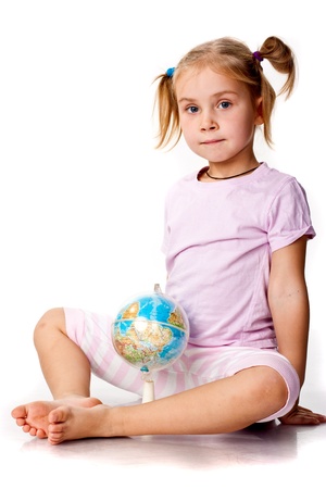 Beautiful girl playing with a globe, pointing a continentの写真素材