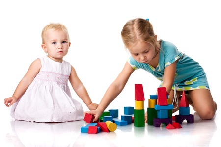 Children building a castle with cubes isolated on whiteの写真素材